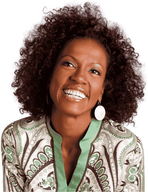 Imagem de uma mulher sorridente com cabelo cacheado, usando roupa com detalhes florais em tons de verde e branco, e brincos grandes.